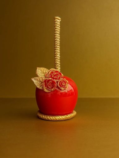 Rote Apfel-Dekoration mit goldfarbenem Stiel und blattförmigen Verzierungen.